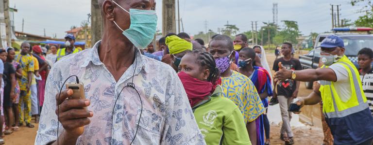 Main in COVID mask waits for food package