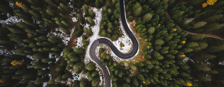 Aerial view of a road winding through a forest