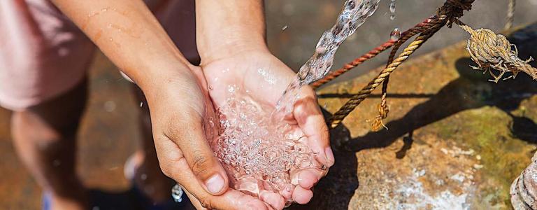 Person washes their hands under flowing tap