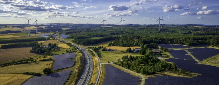 Solar panels and wind turbines across a large landscape