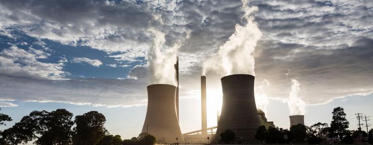 A road heads toward cooling towers of a coal-fired power plant.