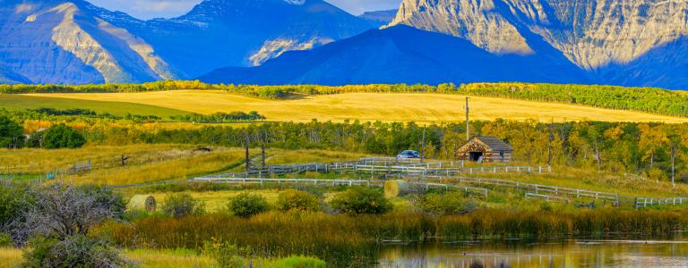 A farmhouse in Alberta, Canada, against a mountain backdrop