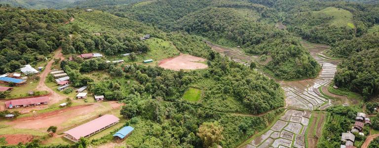 Aerial view of a small agricultural village in the middle of a forest