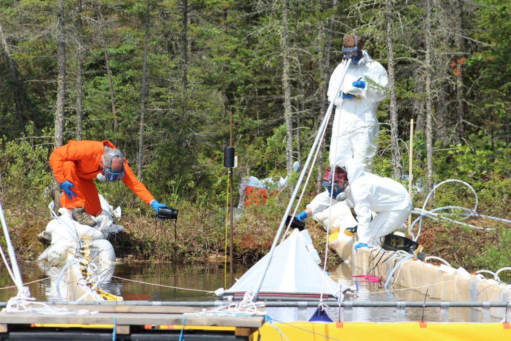 researchers experiment on a lake by pouring oil into a netted area