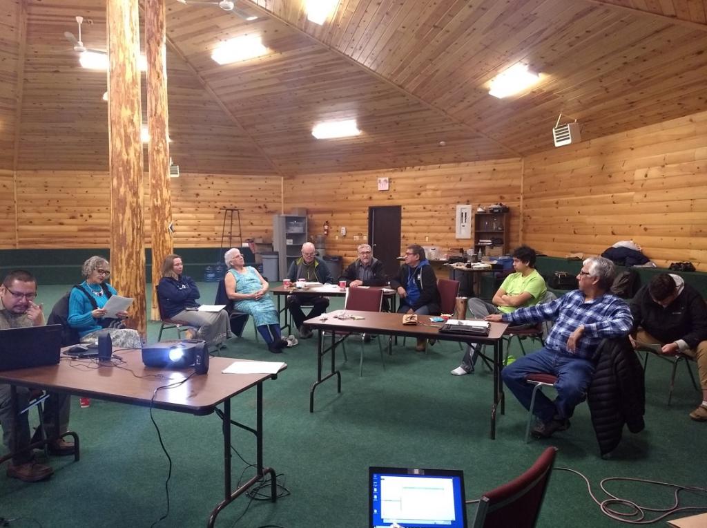 People sitting in a circle working on an Ojibwe translation exercise