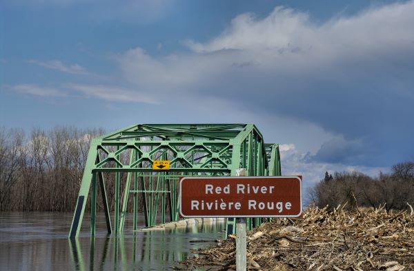 Flooded Red River in Manitoba with bridge in background for story on COVID-19 and how to prepare for crisis